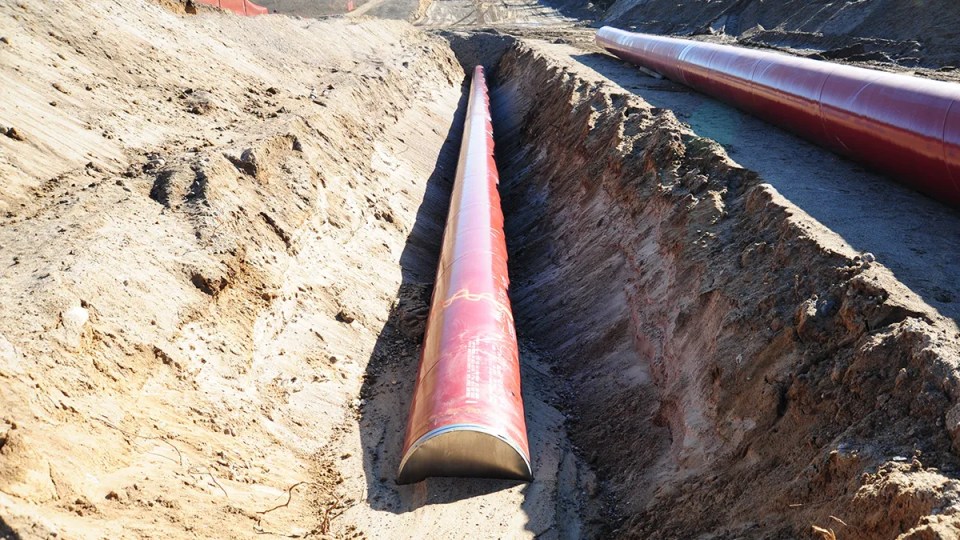 Oleoducto rojo al centro en el sitio de derrame de petróleo Bemidji en Minnesota. El tubo se encuentra dentro de una zanja.